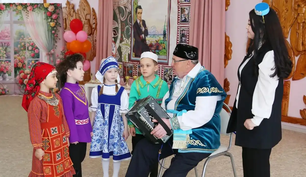 Мероприятие ко дню рождения Тукая в детском саду Нижнекамска поют песню под баян на котором играет пожилой мужчина в национальном татарском костюме
