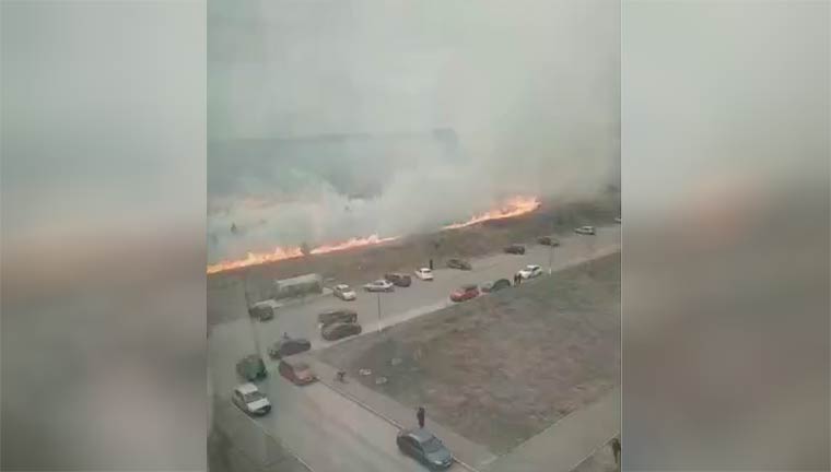 В Нижнекамске огонь на горящем поле подбирается к припаркованным автомобилям