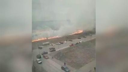 В Нижнекамске огонь на горящем поле подбирается к припаркованным автомобилям