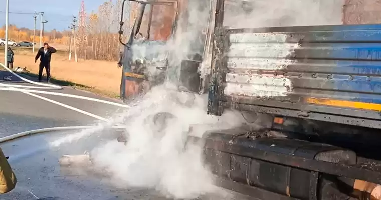 Пожарный тушит огонь в кабине грузовика