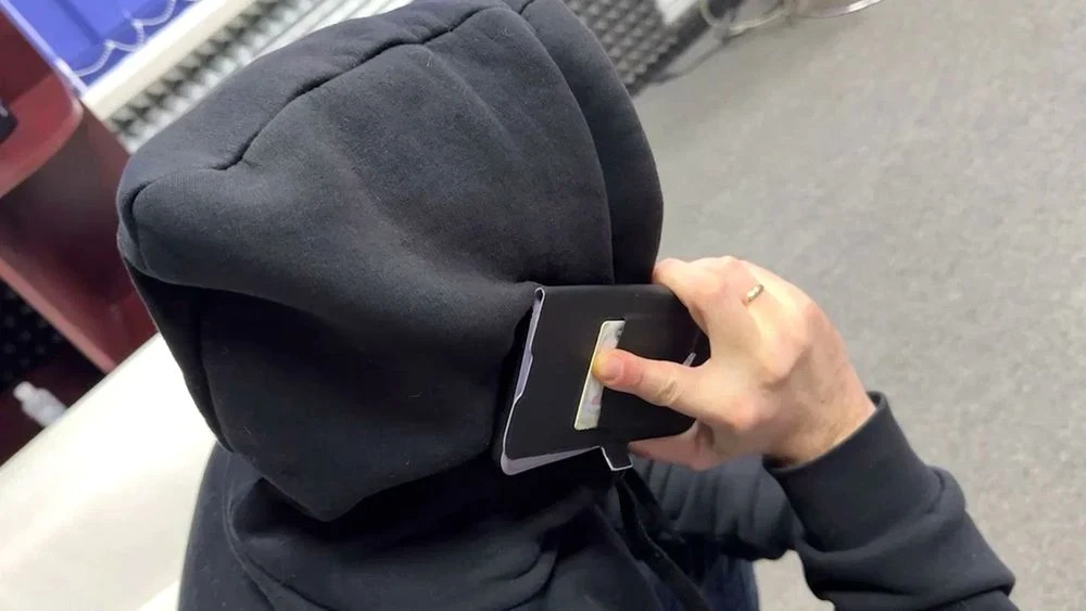 человек в капюшоне разговаривает по телефону