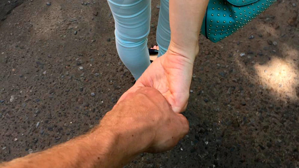 Пара держится за руки