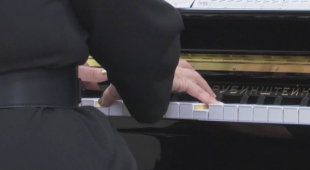 музыкант играет на фортепиано в концертном зале Нижнекамского музыкального колледжа