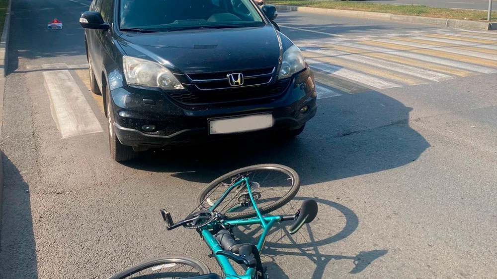 Автомобиль и велосипед на дороге после дтп