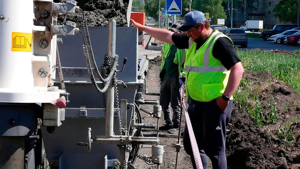 Рабочий укладывает асфальт