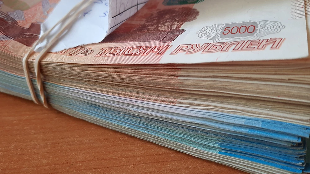 Пачка денег, купюры по 5 000 рублей, на столе