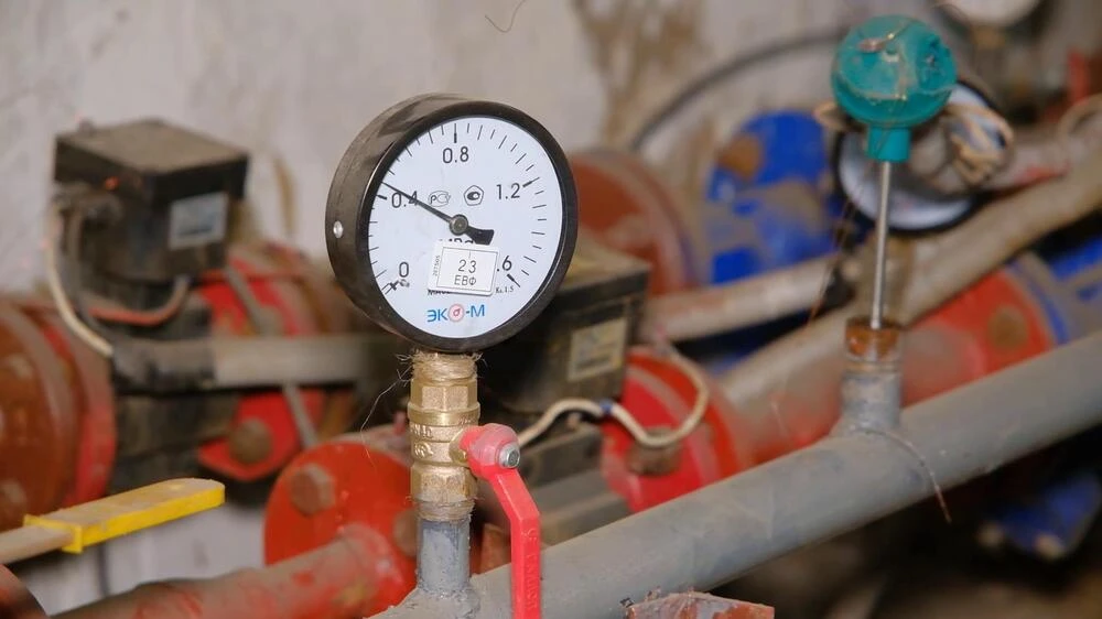 трубы с манометром в подвале жилого многоквартирного дома
