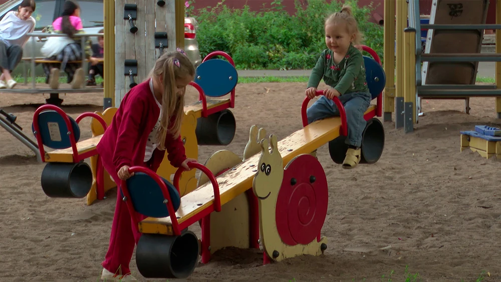 Дети играют на качели