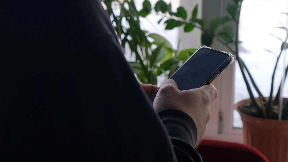 мужчина держит в руках телефон