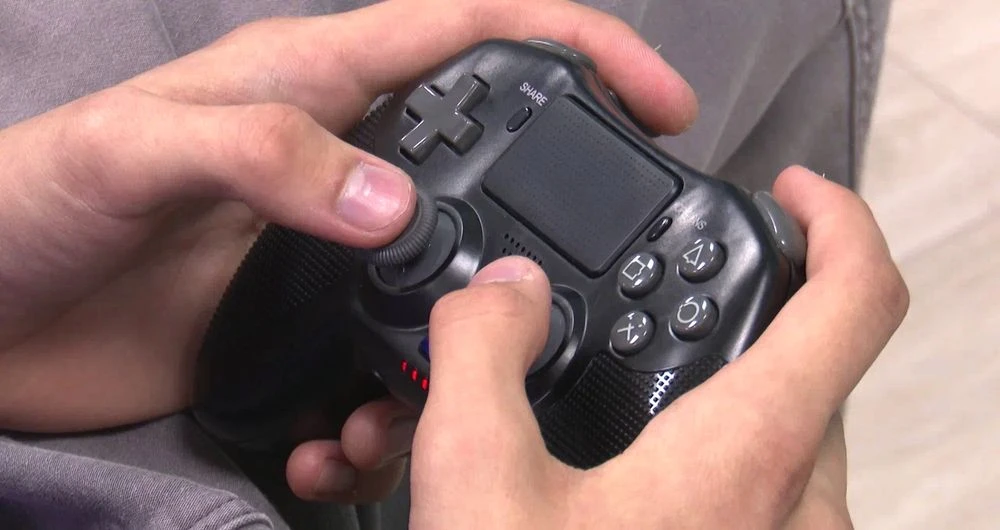 джойстик в руке играющего в компьютерные игры