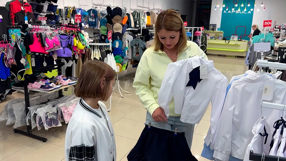 мама и дочь подбирают школьную форму к новому учебному году