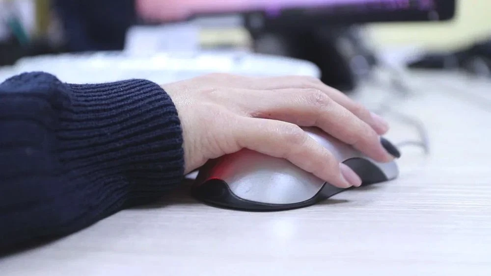 женщина пользуется компьютерной мышью