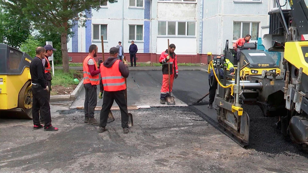 Рабочие укладывают асфальт во дворе