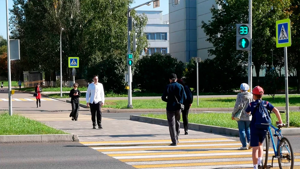 Пешеходы переходят дорогу по пешеходному переходу