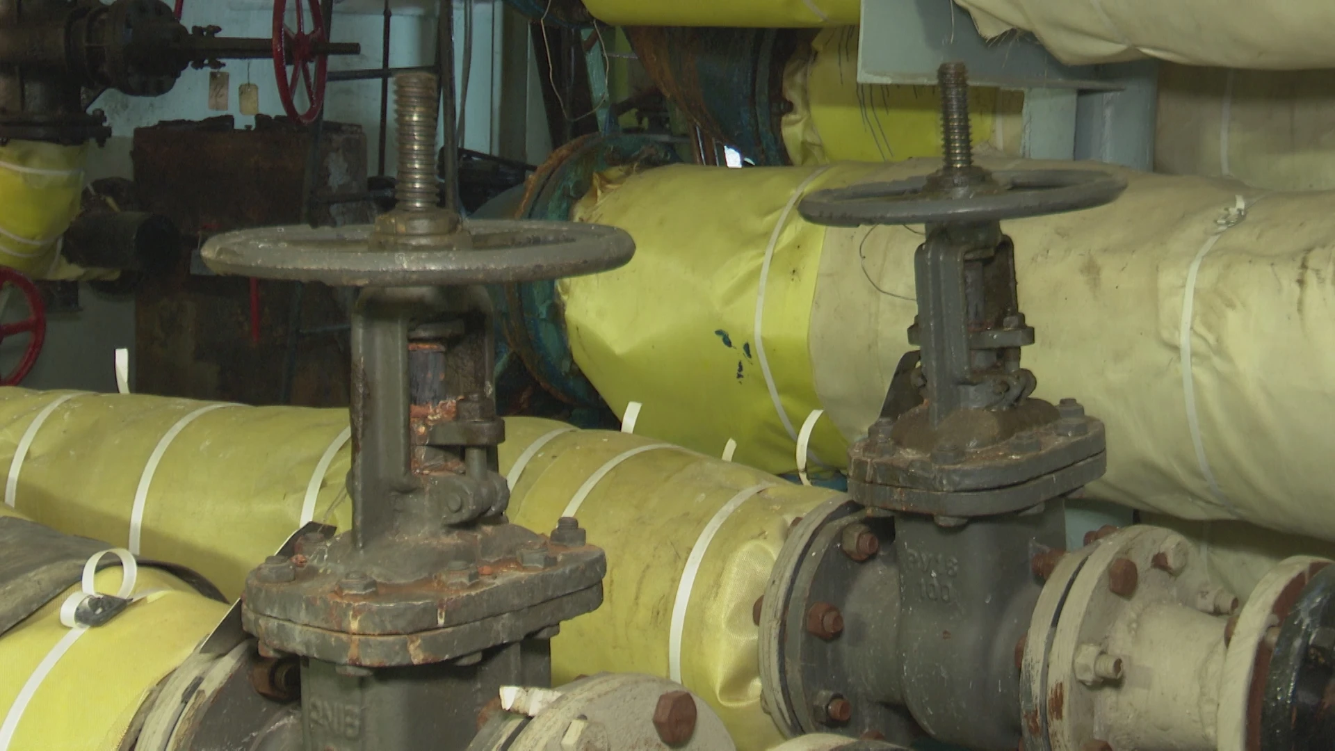 Трубы теплоснабжения с вентилями в подвале дома