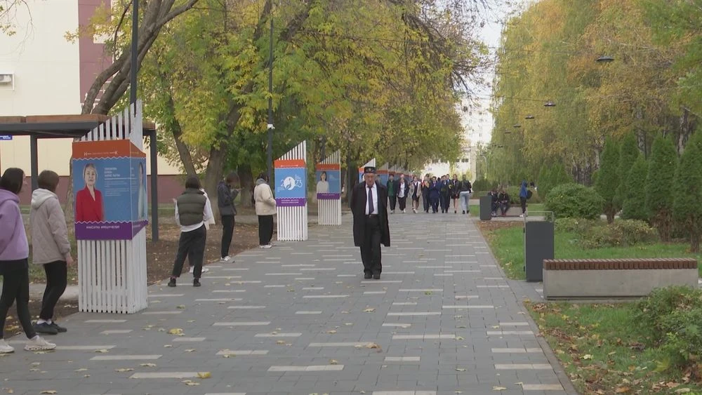 люди идут по тротуару осенью