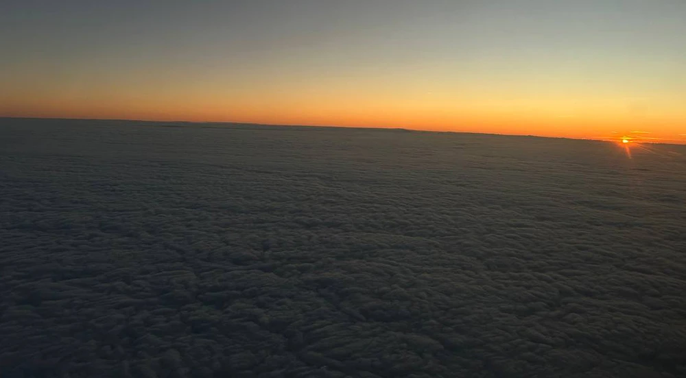 вид на закат из самолета над облаками