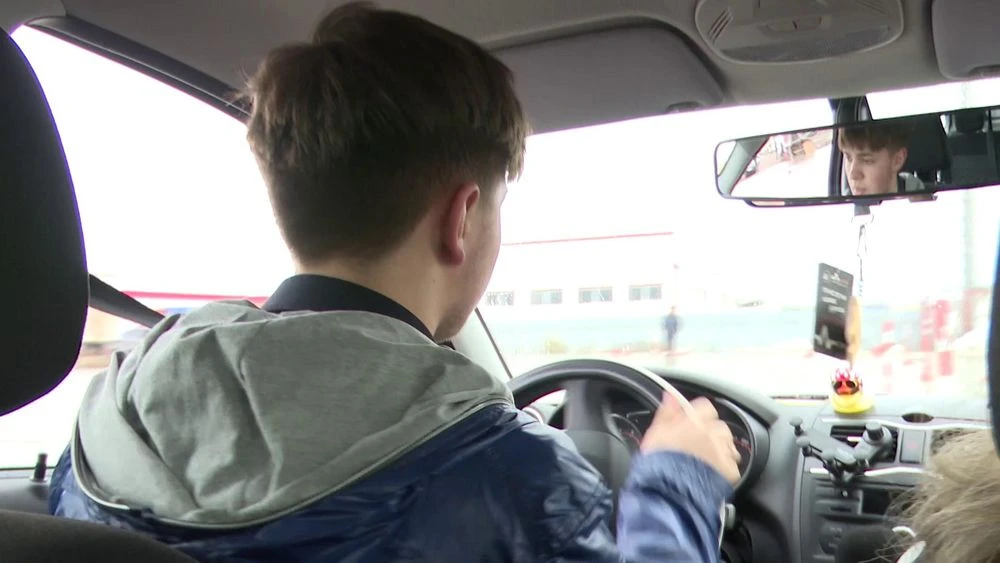 молодой человек за рулём автомобиля