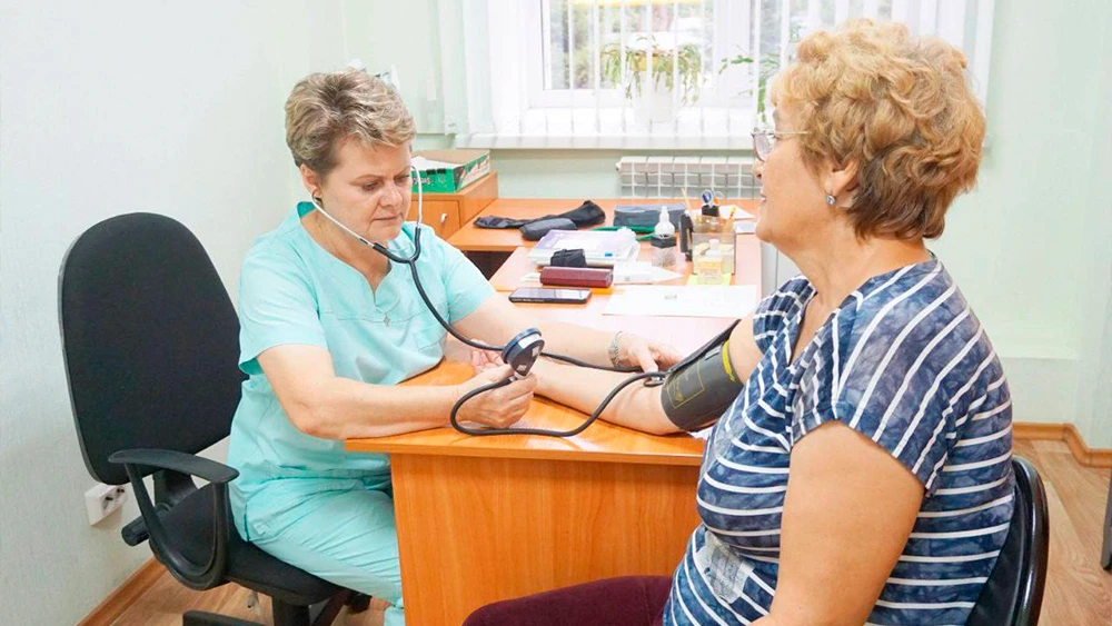 Доктор измеряет давление пациентке