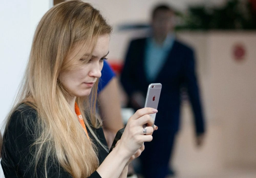 девушка держит айфон