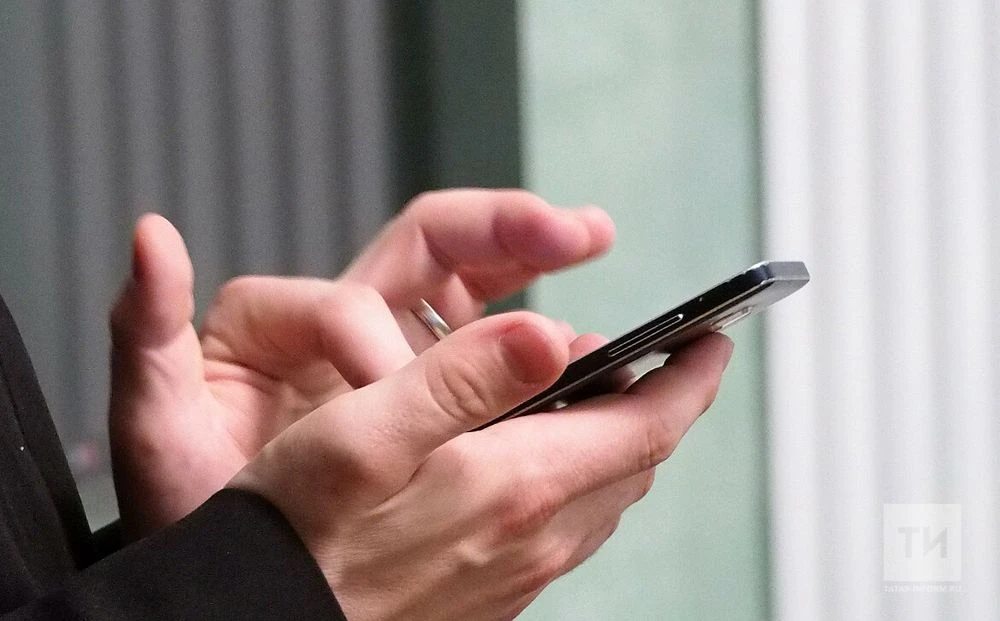 молодой человек держит в руках смартфон