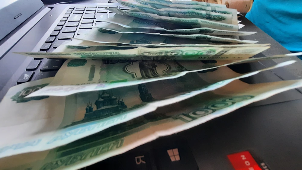 Деньги, тысячерублевые банкноты, на ноутбуке