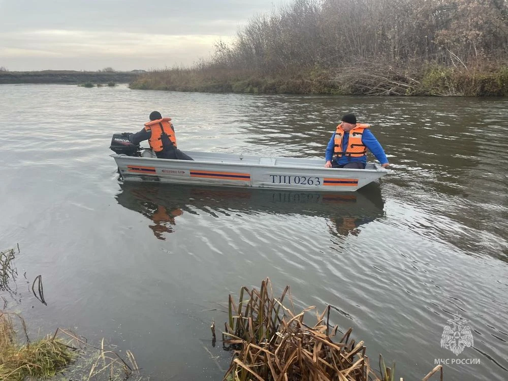 спасатели на лодке ищут утонувшего человека