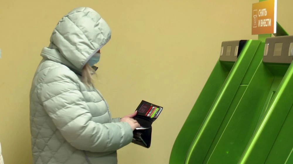 женщина стоит у банкомата