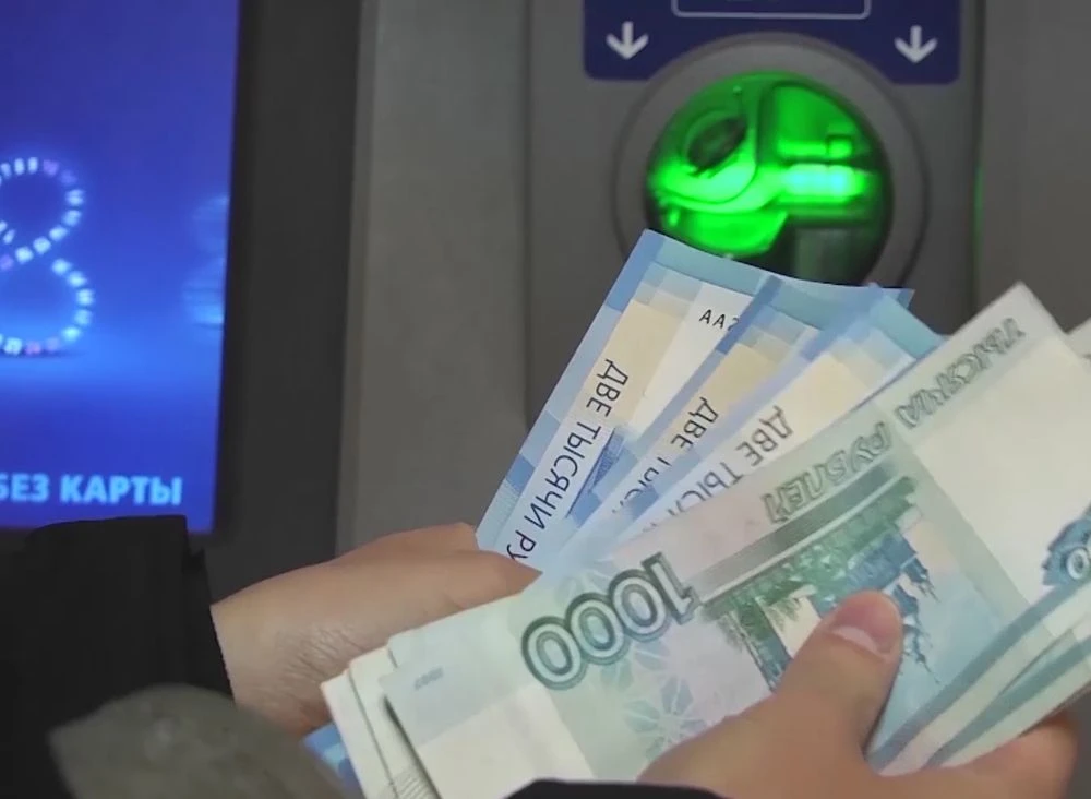 деньги в руках около банкомата