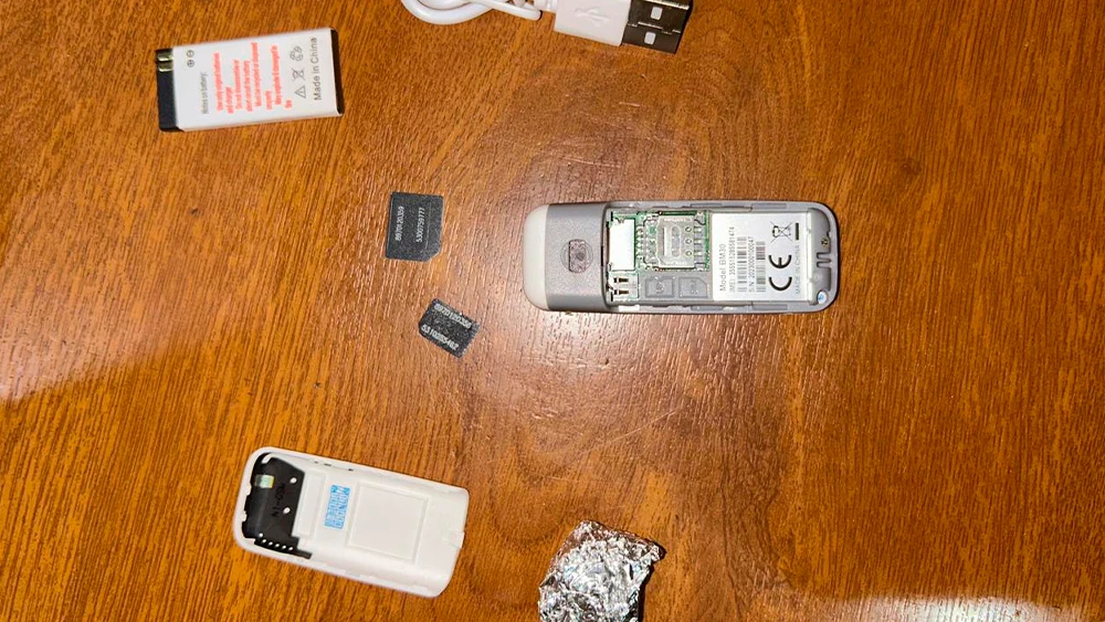 Телефон с двумя SIM-картами, зарядное устройство и сверток с наркотиком