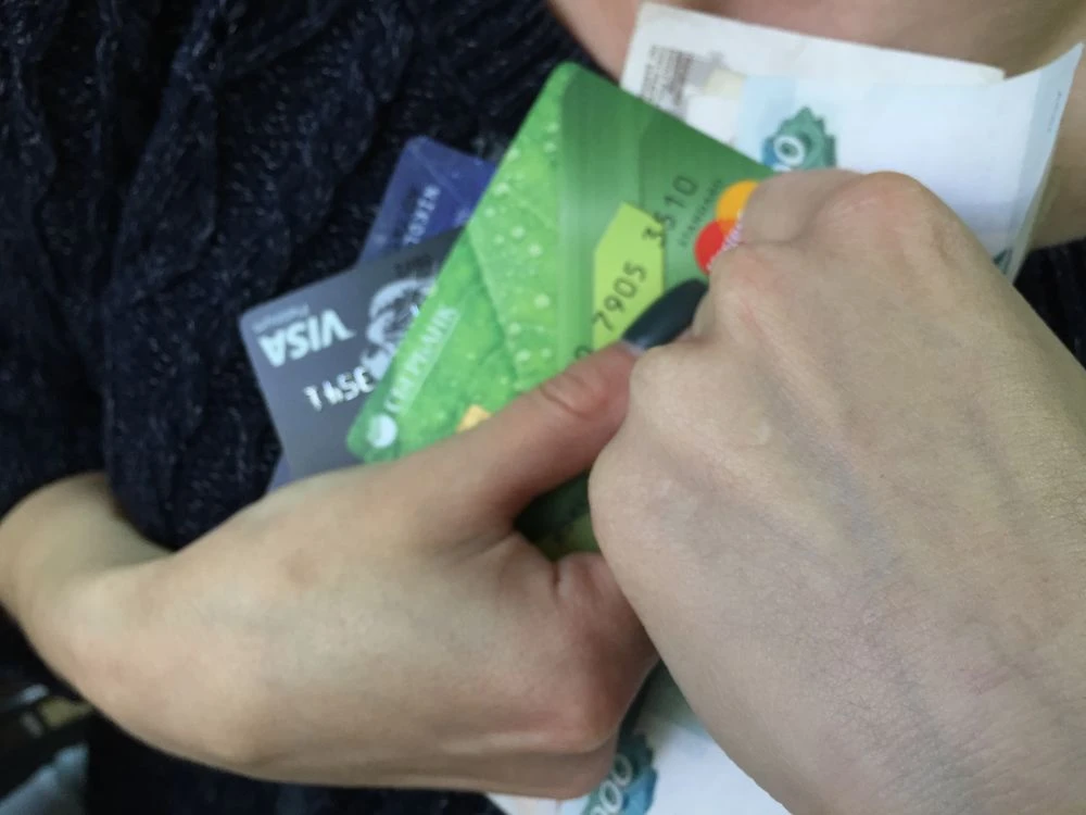 женщина держит в руках банковские карты