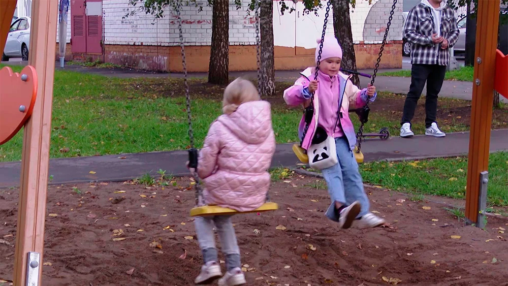 Дети качаются на качелях