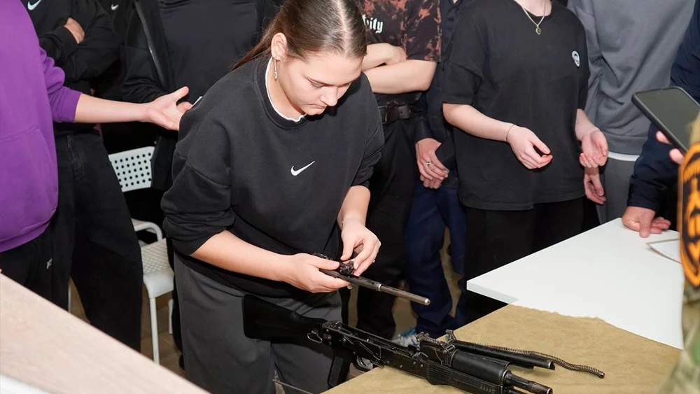 Девушка собирает автомат