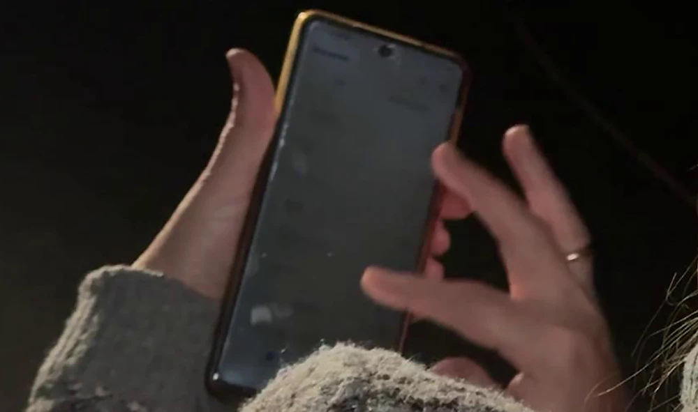 женщина держит в руках смартфон и набирает сообщение