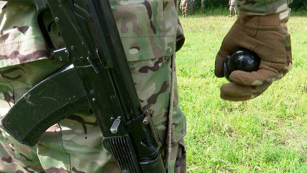 солдат с оружием и гранатой готовится к бою