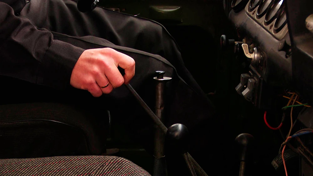 Водитель автомобиля переключает передачу