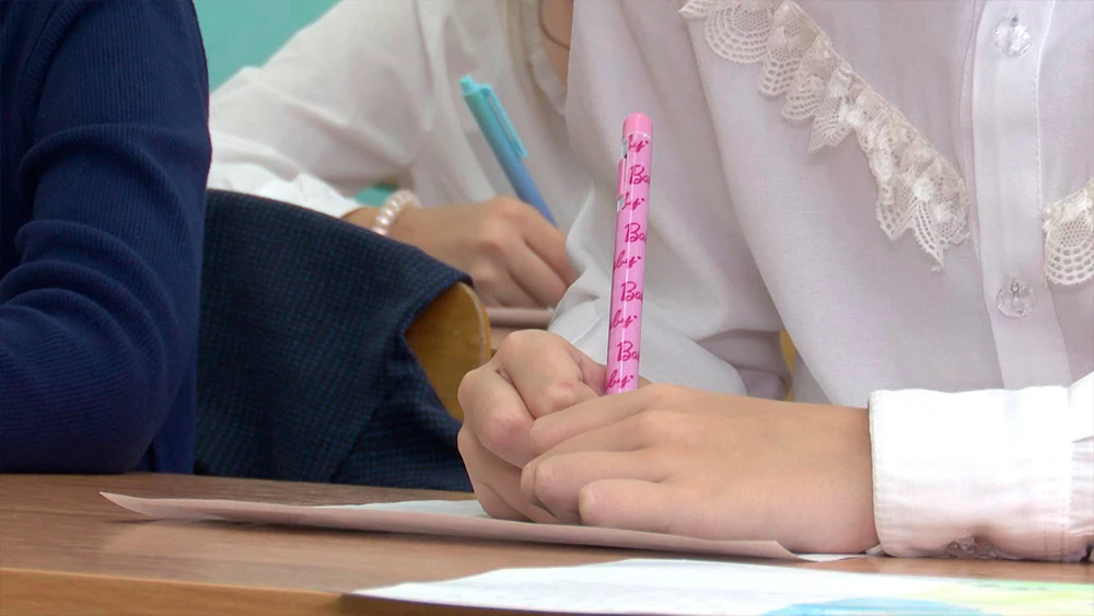 Ручка в руках ученицы в школе