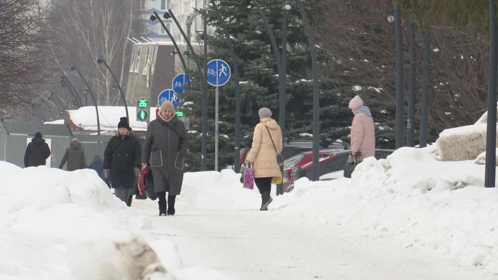 люди идут по тротуару зимой в Нижнекамске