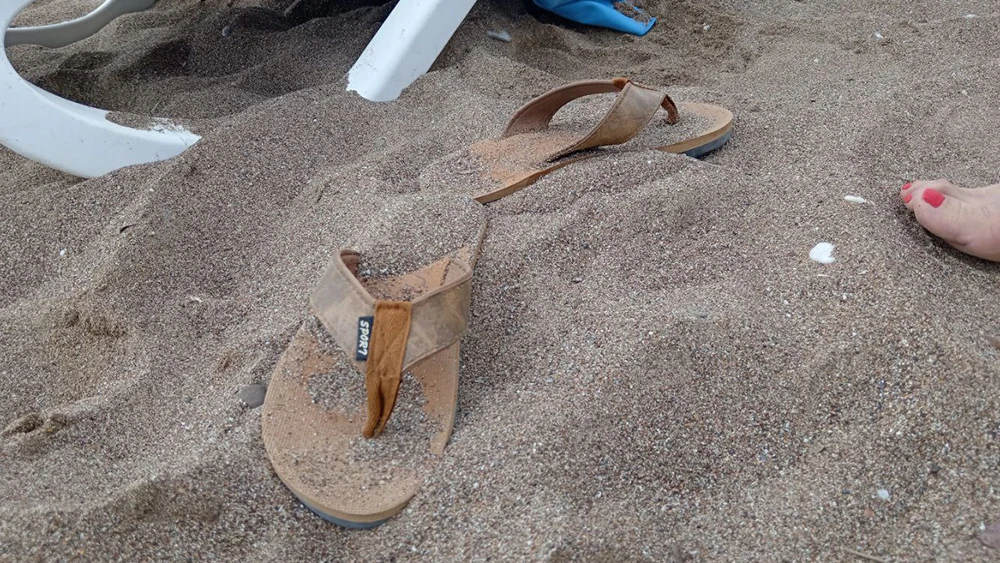 пляжные тапочки на морском песке