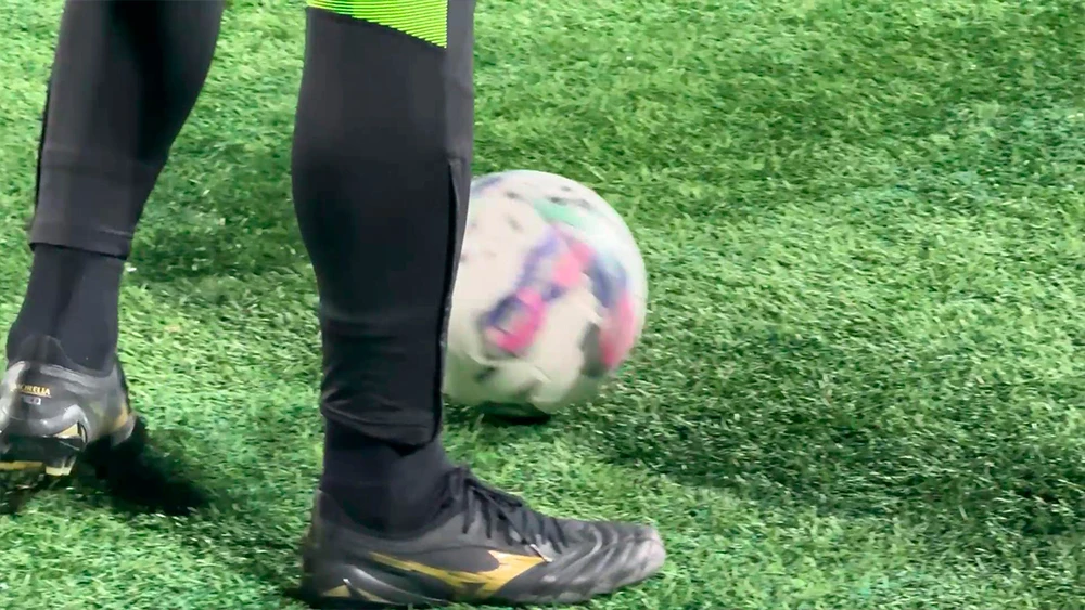 футболист на поле с мячом