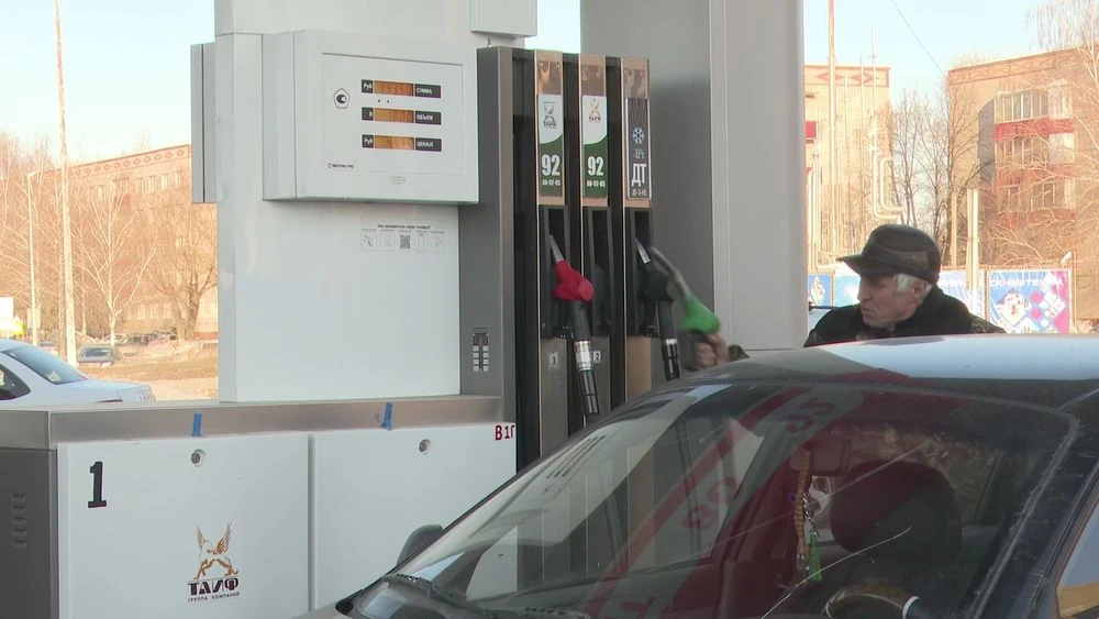 пенсионер на АЗС заправляет машину