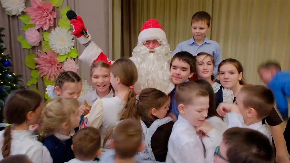 Дети обнимают Деда Мороза