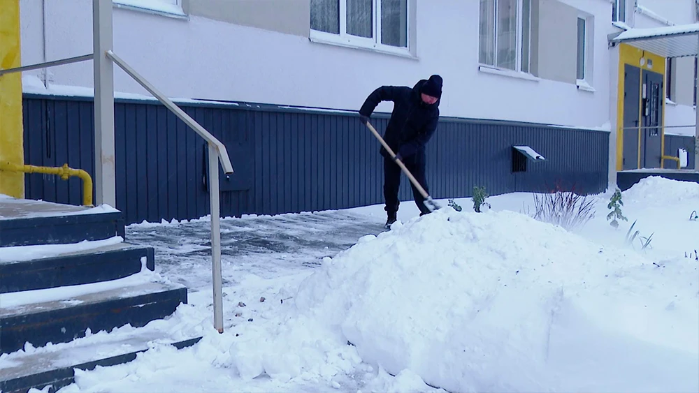 Мужчина убирает снег