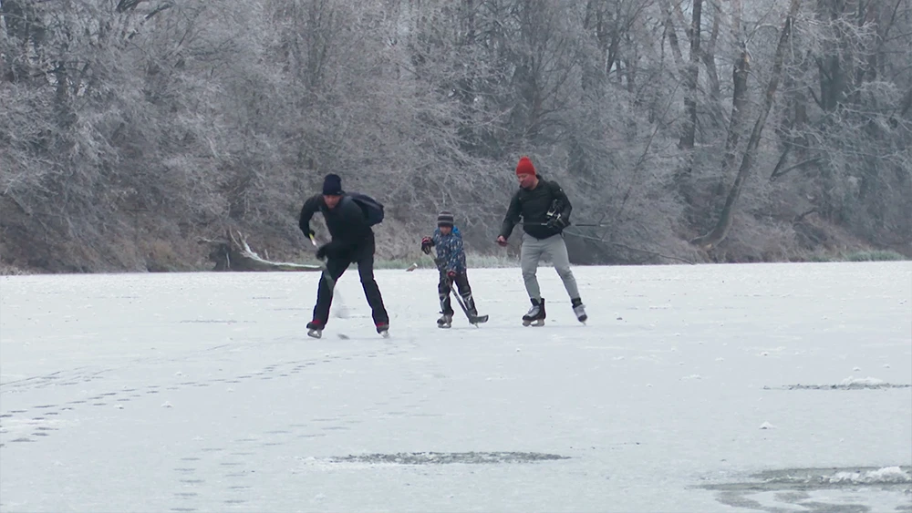 Люди играют в хоккей на замёрзшем озере