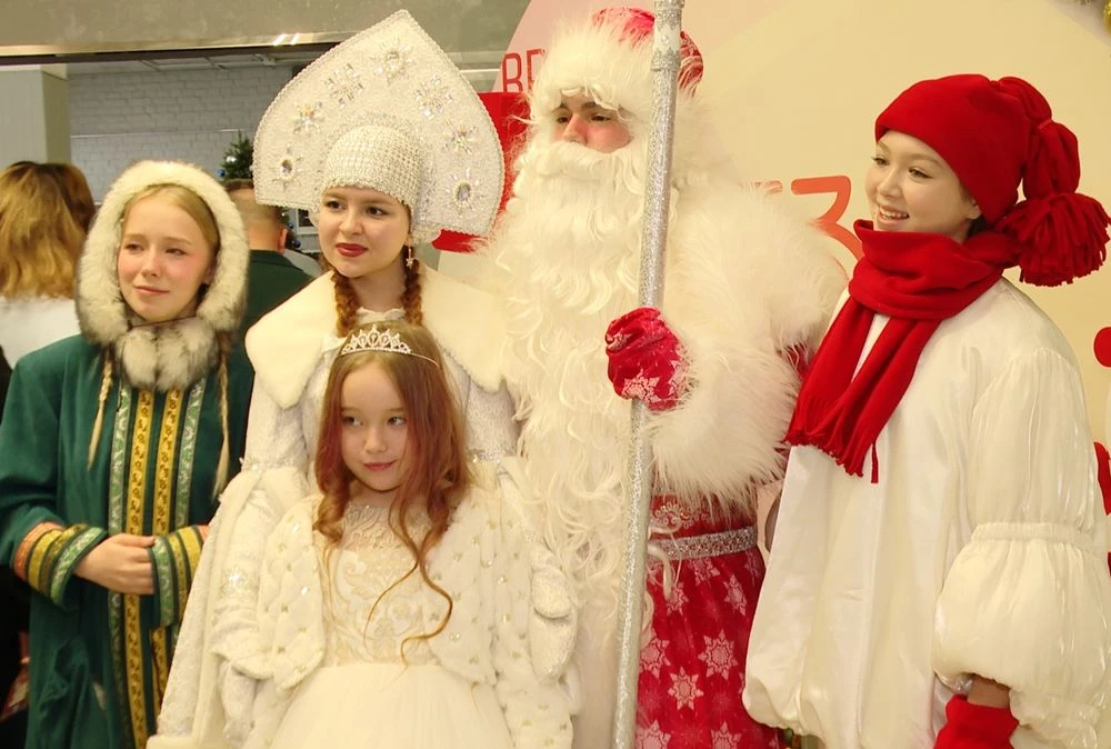 девочка фотографируется с Дедом Морозом и Снегурочкой
