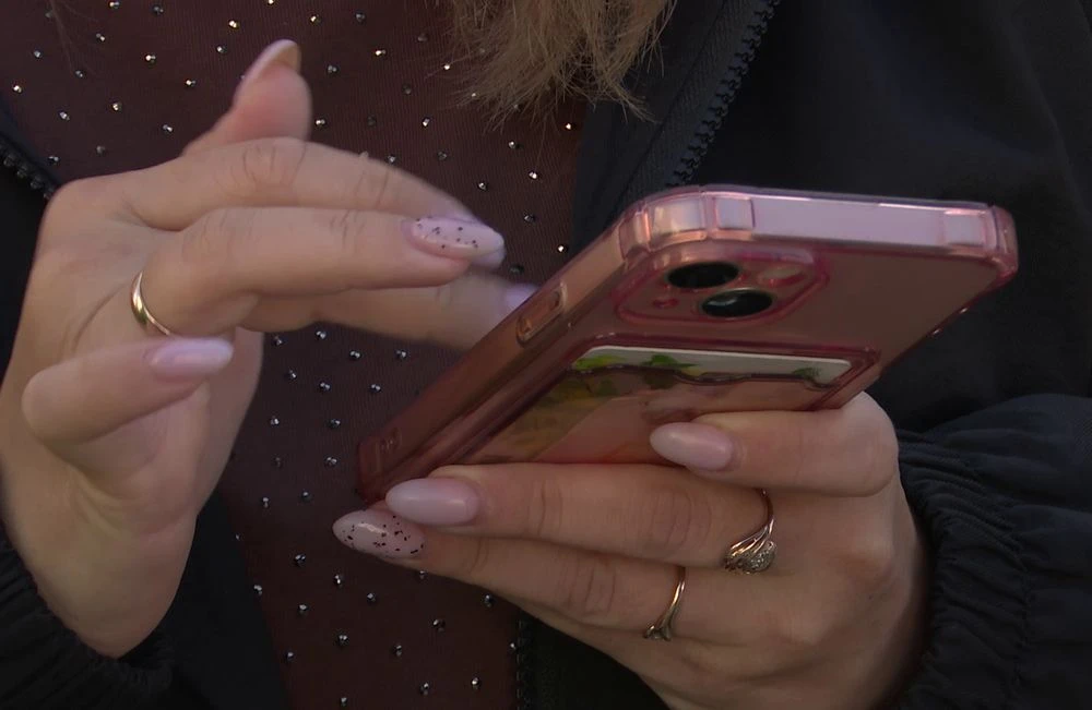 женщина держит смартфон