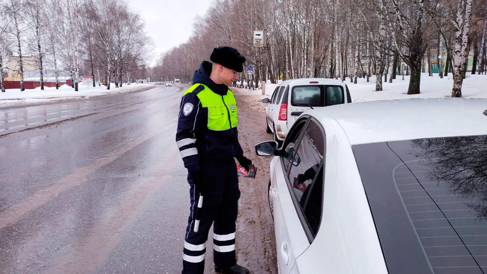 Сотрудник ГАИ проверяет документы у водителя