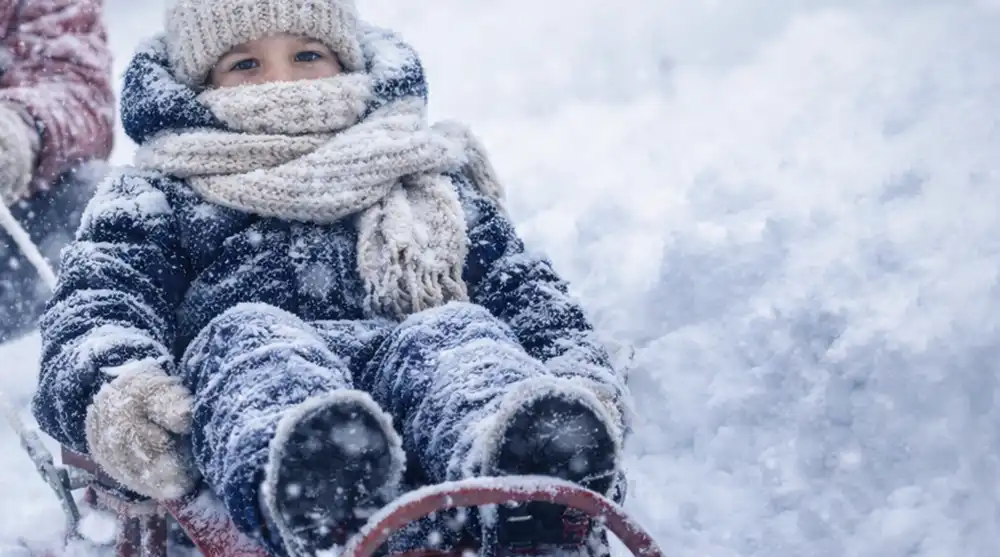 ребенок на санках катится с горки