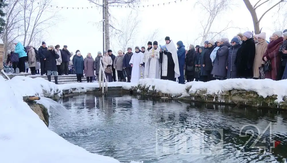 верующие и священнослужители у купели в Крещение