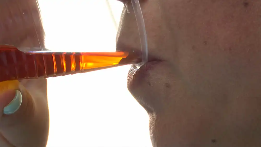 Пьёт коньяк из стаканчика